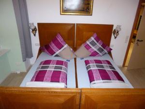 een bed met paarse en witte kussens erop bij Lucky Home Ludwig Appartment in Füssen