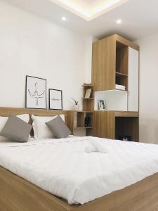 - une chambre avec un grand lit et des draps blancs dans l'établissement Hello SaiGon Homestay, à Hô-Chi-Minh-Ville