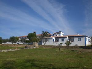 a white house with a palm tree in a field at Tapada da Eira e Chanca in Fortios