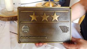 a person holding a gold clutch with five stars at Hotel Jägerhof garni in Bernau am Chiemsee