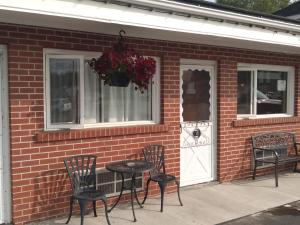 - une table et des chaises à l'extérieur d'une maison en briques dans l'établissement Algoma Motel, à Wawa