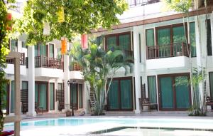 a hotel with a swimming pool in front of a building at The Mantrini Chiang Rai-SHA Extra Plus in Chiang Rai