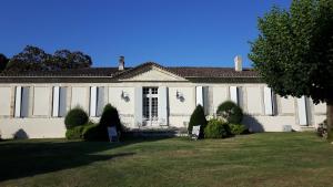 a large white house with a lawn in front of it at La Jouissiere in Soulignac