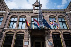 a building with flags on the front of it at Grand Hotel Alkmaar in Alkmaar