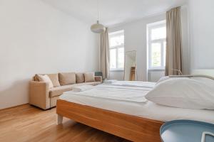 ein Schlafzimmer mit einem großen Bett und einem Sofa in der Unterkunft UNIVERSUM APARTMENT in Wien
