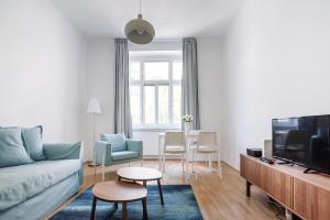 ein Wohnzimmer mit einem Sofa und einem TV in der Unterkunft UNIVERSUM APARTMENT in Wien
