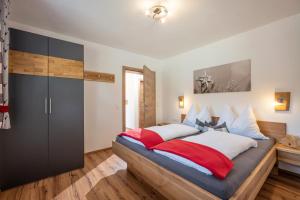 ゲルロスベルクにあるApart Bergluftのベッドルーム1室(大型ベッド1台、赤と白の枕付)