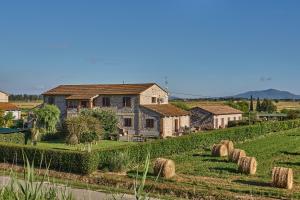 a house on a hill with hay bales at CASA VACANZE ARCOBALENO in Grosseto