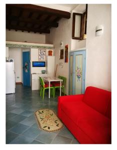 a living room with a red couch and a table at LA PERLA in Isola del Giglio