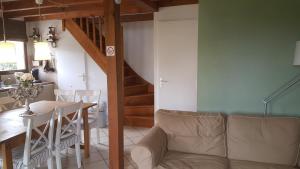 Village Océlandes 187 في سان جوليان-أون-بورن: غرفة طعام ومطبخ مع طاولة وكراسي