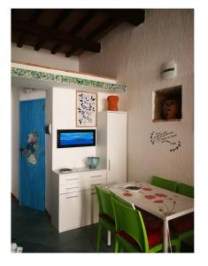 Isola del Giglio的住宿－LA PERLA，一间带桌子和绿色椅子的用餐室