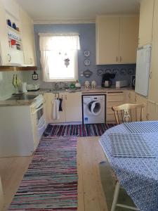 a kitchen with a washing machine and a table with a rug at Holiday Home Småland in Fågelfors