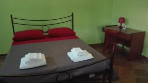 una camera da letto con un letto, due asciugamani e una scrivania di Il Giardino di Silvia a Veglie