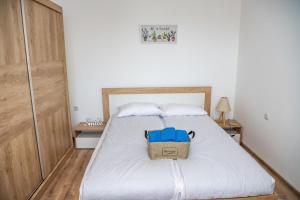 um quarto com uma cama branca e um saco azul em Apartment Vazrozhdenska em Veliko Tarnovo