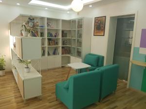 a room with two chairs and a table and bookshelves at Tara Lodge in Ulaanbaatar