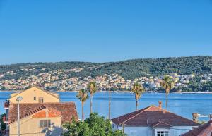 eine Gruppe von Häusern und Palmen neben dem Wasser in der Unterkunft Hotel Trogirski Dvori in Trogir