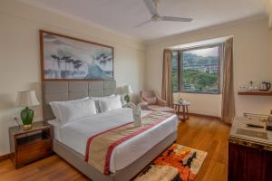 a bedroom with a large bed and a large window at Larisa Shimla in Shimla