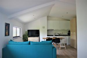 uma sala de estar com um sofá azul e uma cozinha em Infusion em Óbidos