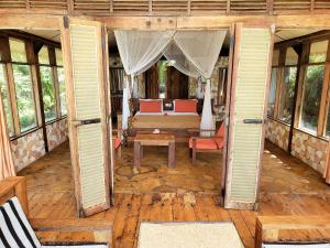 Seasons Lodge Zanzibar في بونجوي: باب مفتوح لغرفة بها سرير وطاولة