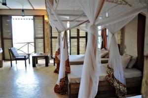 Seasons Lodge Zanzibar في بونجوي: غرفة نوم بسريرين تحتوي على ناموسيات
