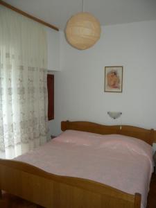 ein Schlafzimmer mit einem Holzbett mit einer weißen Tagesdecke in der Unterkunft Apartment Per - sea view & parking space in Banjol