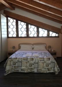 sypialnia z dużym łóżkiem i oknami w obiekcie B&B "al Pesce Vela" w mieście Albese Con Cassano