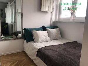 een kleine slaapkamer met een bed met een spiegel bij DELUXE PAŃSKA APARTMENTS in Warschau
