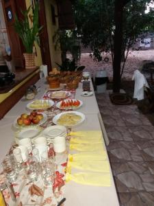 a long table with plates of food on it at Pousada Sombra do Cajueiro in Alter do Chao