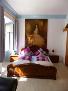 a bedroom with a bed with a painting on the wall at Lucky Home Sissi Appartment in Füssen