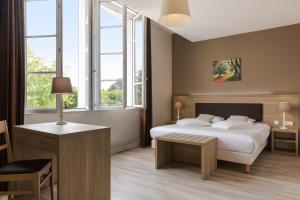 Schlafzimmer mit einem Bett, einem Tisch und Fenstern in der Unterkunft Hôtel Le Haut des Lys in Villandry
