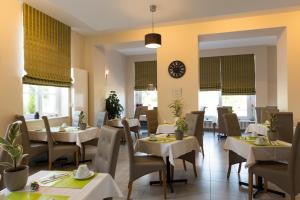 a restaurant with tables and chairs and a clock on the wall at Hôtel Le Haut des Lys in Villandry