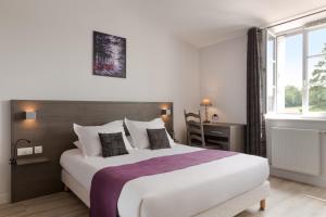 a hotel room with a large bed and a window at Hôtel Le Haut des Lys in Villandry