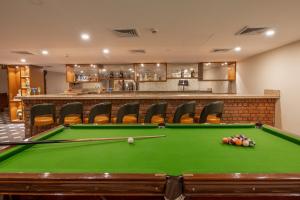 a pool table in a room with a bar at Larisa Shimla in Shimla