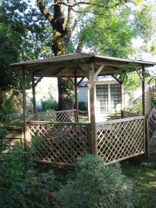 einen hölzernen Pavillon vor einem Baum in der Unterkunft Le Nid D'Hirondelles in Donges