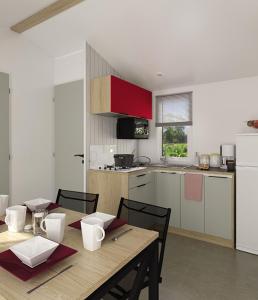 eine Küche mit einem Holztisch mit Stühlen und einem Esszimmer in der Unterkunft Camping de la Plage - Damgan in Damgan + 109 Fotos