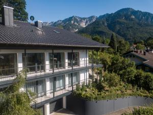 uma casa com uma varanda com montanhas ao fundo em Alpen Air exklusive Apartments em Bad Reichenhall