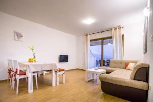 a living room with a table and a couch at Mare E Sabbia in Lopar