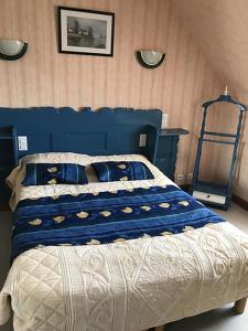 a bedroom with a blue bed with a blue head board at Gîtes du Ménez-Hom in Plomodiern