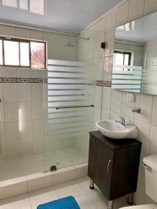een badkamer met een wastafel, een douche en een bad bij Aloha Hostel in Bogota