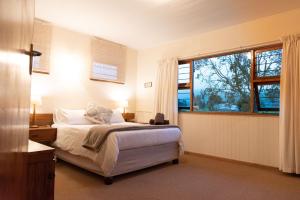 a bedroom with a bed and a large window at Natures Way Farmhouse in The Crags
