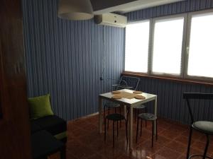 Cette chambre comprend une table, des chaises et des fenêtres. dans l'établissement Moni Apartment, à Nessebar