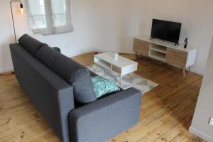 a living room with a couch and a tv at Bel appartement avec vue sur vézère in Uzerche