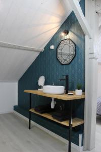 a bathroom with a sink and a blue wall at Bel appartement avec vue sur vézère in Uzerche