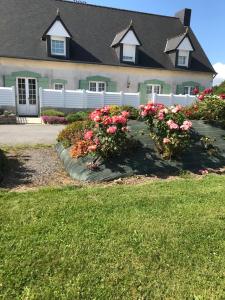 a house with pink flowers in front of a yard at Gîtes du Ménez-Hom in Plomodiern