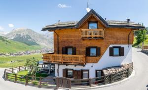 duży drewniany dom z balkonem w obiekcie Tea Bastian w Livigno