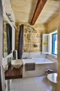 ein Badezimmer mit einer Badewanne und einem Waschbecken in der Unterkunft MYN Zondadari in Rabat