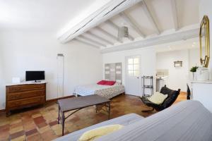 a living room with two beds and a television at Studio ensoleillé, typique centre historique, wifi in Aix-en-Provence