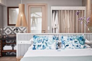 a bedroom with a bed with blue and white pillows at Antigoni Seaside Resort in Ormos Panagias