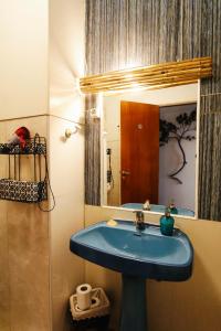 a bathroom with a blue sink and a mirror at Olive Hostel Lagos in Lagos