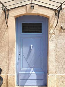 eine blaue Tür in einem Backsteingebäude mit in der Unterkunft La Médéenne in Alairac